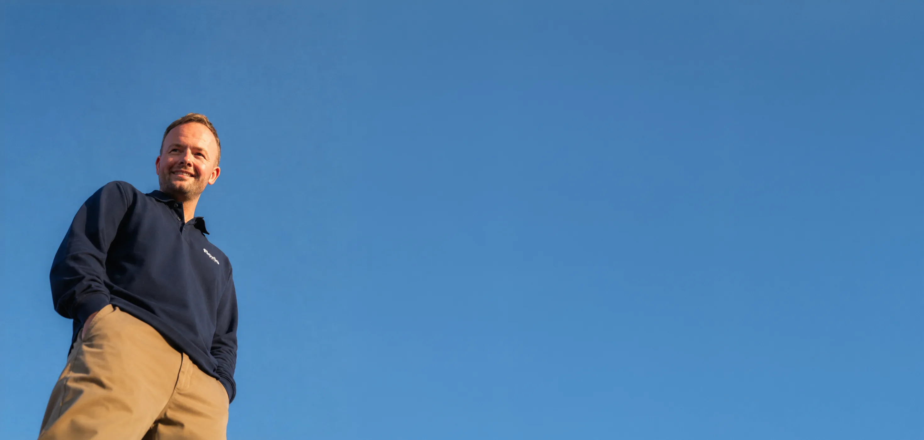 Danny Clark standing under a clear blue sky